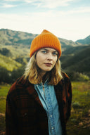 Woman wearing the Wyeth Parker Wool Beanie in Orange outdoors